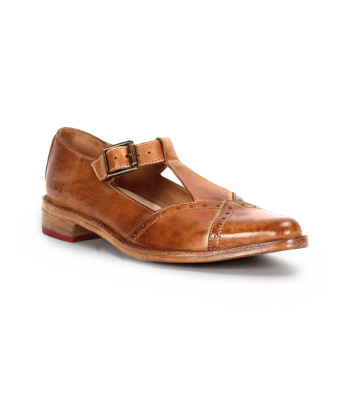 The Bed|Stü Jenny is a single brown leather Mary Jane shoe featuring a buckle strap, cushioned insole, low wooden heel, and brogue detailing, displayed on a white background.