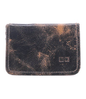Introducing the Jeor by Bed|Stü, a compact card wallet showcased against a plain white background. Crafted from worn brown leather with prominent scratches and scuffs, this rustic piece exudes character and suggests a rich history of everyday use. Multiple credit card slots ensure functionality, while its timeless design offers enduring style.