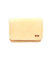 A small, beige rustic leather card wallet, the Jeor by Bed|Stü, featuring two small square accents in the bottom right corner, photographed on a white background.