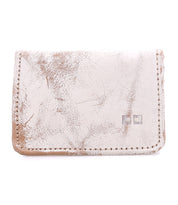 Introducing the Jeor by Bed|Stü—a compact, rustic leather card wallet in a light hue, distinguished by its visible creases and scuffs for authentic vintage appeal. Two small square metal accents adorn the front, while convenient credit card slots ensure easy organization without compromising style.