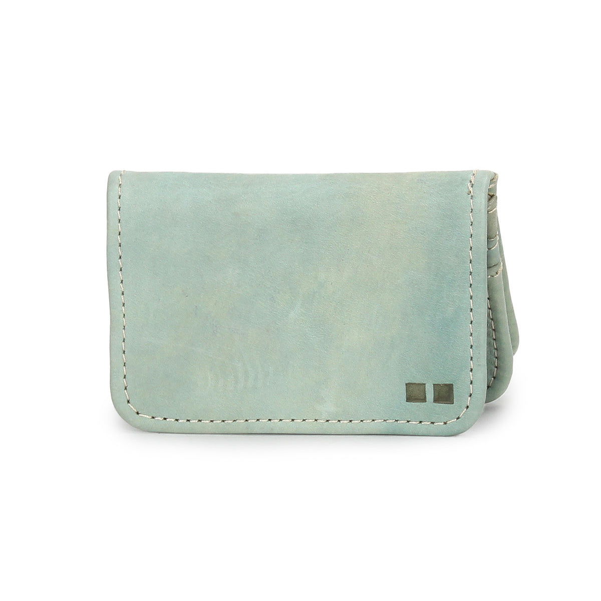 The Jeor card wallet by Bed|Stü features light blue rustic leather with visible stitching and two small metallic square accents on the bottom right corner. Designed with compact credit card slots, it is displayed against a white background.
