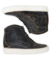 Two worn black leather Bed|Stü Joyce II high-top sneakers with white rubber soles are placed side by side on a white background, displaying their outer sides. These lace-up front shoes feature a subtle hidden heel for added style and lift.