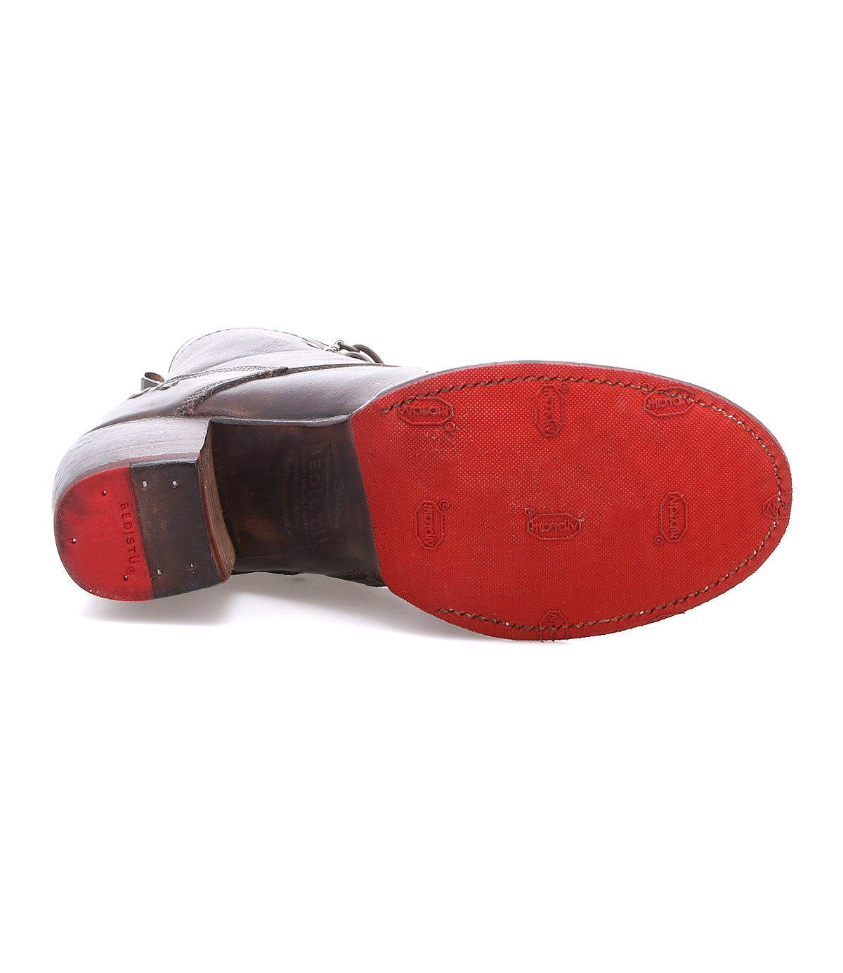 A brown leather dress shoe from Bed|Stü, the Judgement, is shown from the bottom, highlighting its red rubber sole with embossed branding and edge stitching, and features a cushioned insole for enhanced comfort.
