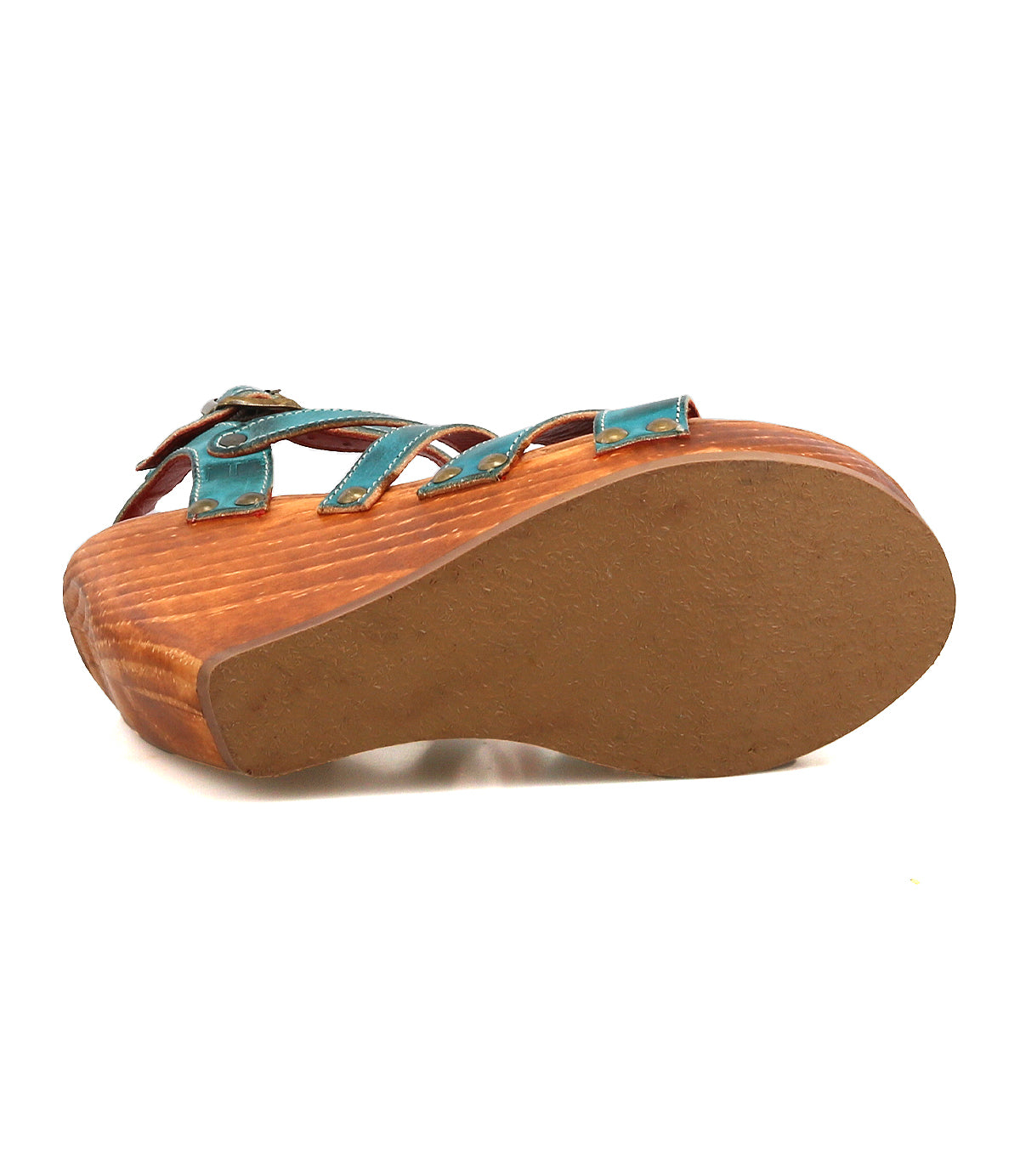 The Juliana II by Bed|Stü is shown from the bottom, featuring its solid sole and the textured wood grain platform beneath a strappy teal upper.