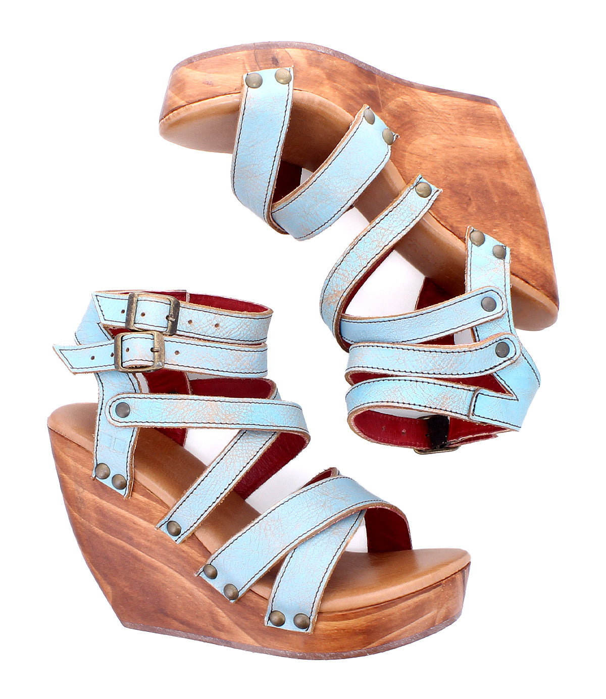 A pair of Bed|Stü Juliana II women's platform sandals, featuring a strappy light blue upper, buckle closures, and wooden wedge soles, displayed on a white background.