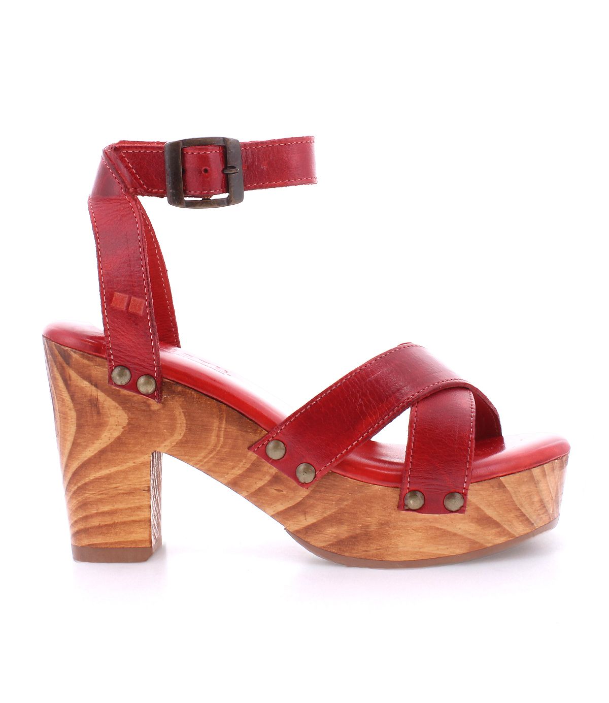 The Bed|Stü Kalah sandal is shown in a side view, featuring red leather with a sustainably sourced wooden platform heel, adjustable ankle strap, and metal rivet details.