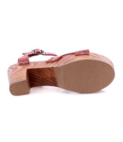 The Kalah sandal by Bed|Stü is shown from the bottom, showcasing the sole and heel details. This platform features a sustainably sourced wooden heel, offering an eco-friendly touch to its stylish design with a red strap.