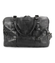 The Bed|Stü Keg is a black vegetable tanned leather duffel bag featuring dual handles, a detachable shoulder strap, and stitched detailing on the front.