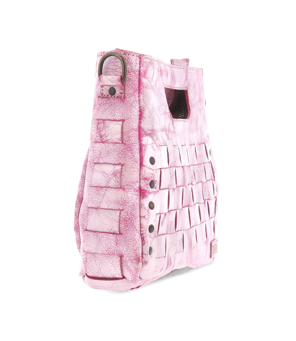 The Bed|Stü Keiki is a pink textured handbag featuring a woven design, metal rivets, an adjustable strap, and a rectangular hand slot, shown on a white background.
