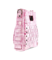 The Bed|Stü Keiki is a pink textured handbag featuring a woven design, metal rivets, an adjustable strap, and a rectangular hand slot, shown on a white background.