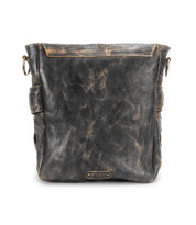 Introducing the Kure messenger bag by Bed|Stü – a distressed black leather bag crafted from vegetable-tanned leather, featuring a front zipper pocket, side buckles, metal loops, a small Bed|Stü brand tag at the bottom, and a distinctive handwoven strap for added style and durability.