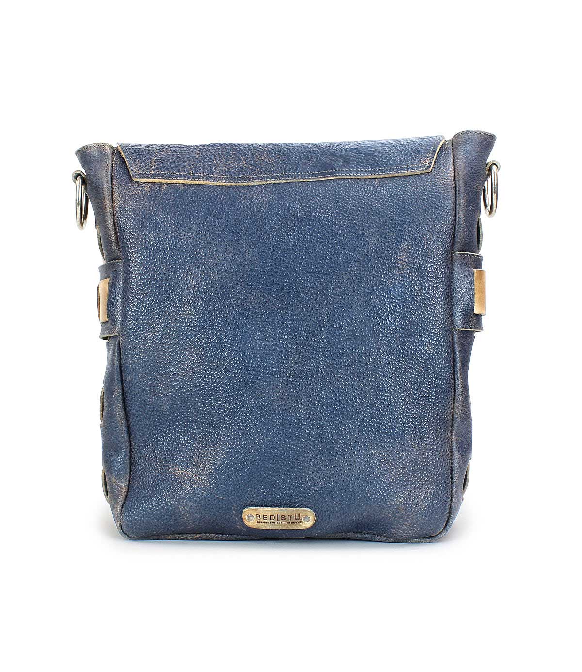 Introducing the Kure by Bed|Stü: a square blue leather crossbody bag with a flap top and metal logo plate on the front, featuring a stylish handwoven strap, photographed against a white background.