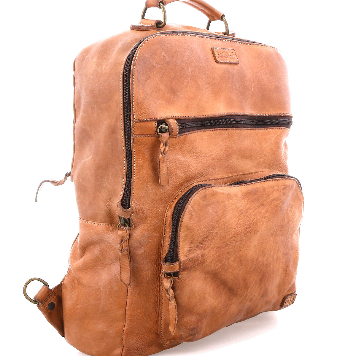 The Bed|Stü Lafe brown leather backpack features two zippered front pockets, a top handle, and metal hardware, designed as a 17-inch laptop bag that combines style and practicality—shown here on a white background.