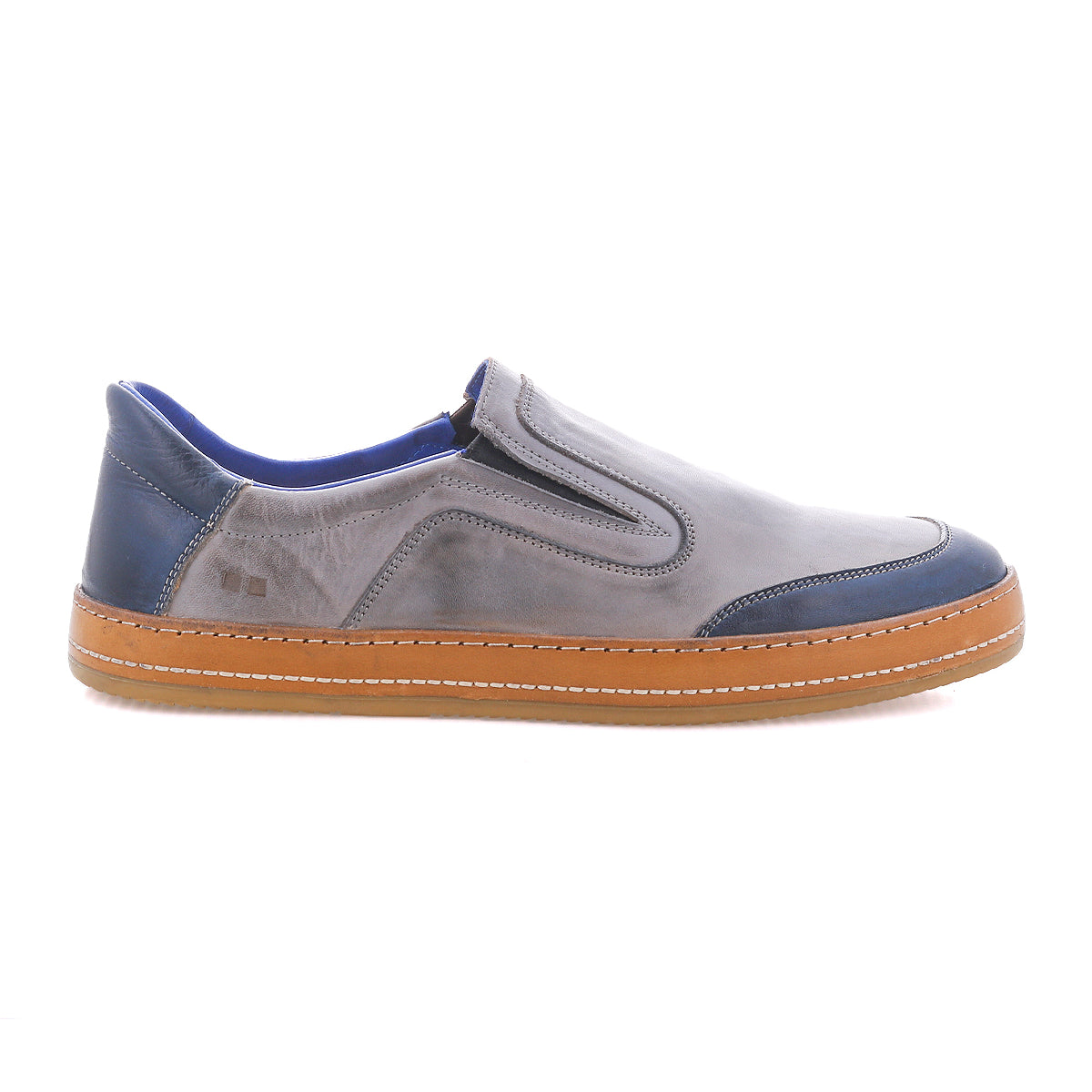 The Bed|Stü Lanius features a timeless silhouette in gray and blue with a brown rubber sole, visible stitching, and elastic side panels, shown in profile against a white background.