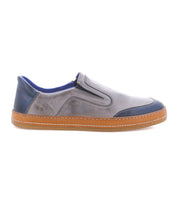 The Bed|Stü Lanius features a timeless silhouette in gray and blue with a brown rubber sole, visible stitching, and elastic side panels, shown in profile against a white background.