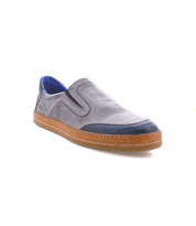 Introducing the Bed|Stü Lanius: a gray slip-on shoe featuring a tan sole and vibrant blue accents on the toe and inner lining. Displayed against a crisp white background, this style uses bold color blocking to give a contemporary update to a classic silhouette.