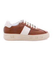 The Law sneaker by Bed|Stü features a brown and white low-top design with white laces, a thick white sole, and a white side panel. Shown in profile on a plain background, this timeless shoe exemplifies Italian craftsmanship and luxury leather construction.