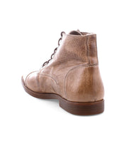 The Bed|Stü Leonardo tan leather lace-up ankle boot is pictured from the back right side, highlighting its detailed stitching and brown flexible rubber outsole against a white background.