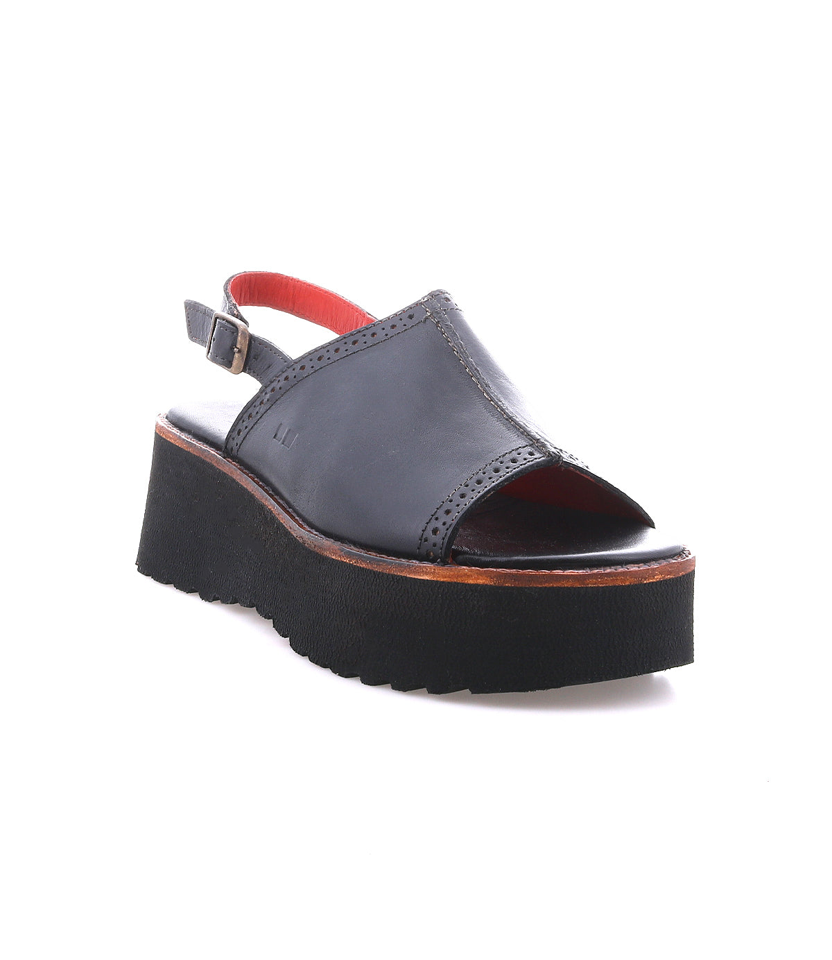 The Bed|Stü Library is a black leather platform sandal featuring an open toe, a back strap with buckle, and a thick ridged sole—displayed on a white background, this retro design captures the bold spirit of ‘90s style.