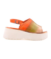The Bed|Stü Library sandal features vibrant orange and green hues, an open-toe platform silhouette with a white chunky sole, and an adjustable ankle strap—seen from the side, it perfectly channels ‘90s style and retro footwear trends.