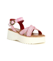 The Bed|Stü Lift sandal features crisscross pink straps, an ankle buckle, and a thick white platform sole; this stylish strappy sandal is shown on a white background.