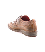 A single Lita K II classic derby dress shoe by Bed|Stü in worn brown leather is displayed on a white background, angled to highlight the back and side features, including brogue detailing with decorative stitching and a slightly scuffed heel.