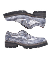 Two Lita K III shoes by Bed|Stü, crafted from distressed gray leather with lace-up fronts and thick black treaded soles that blend vintage-inspired details, are displayed side by side against a white background.
