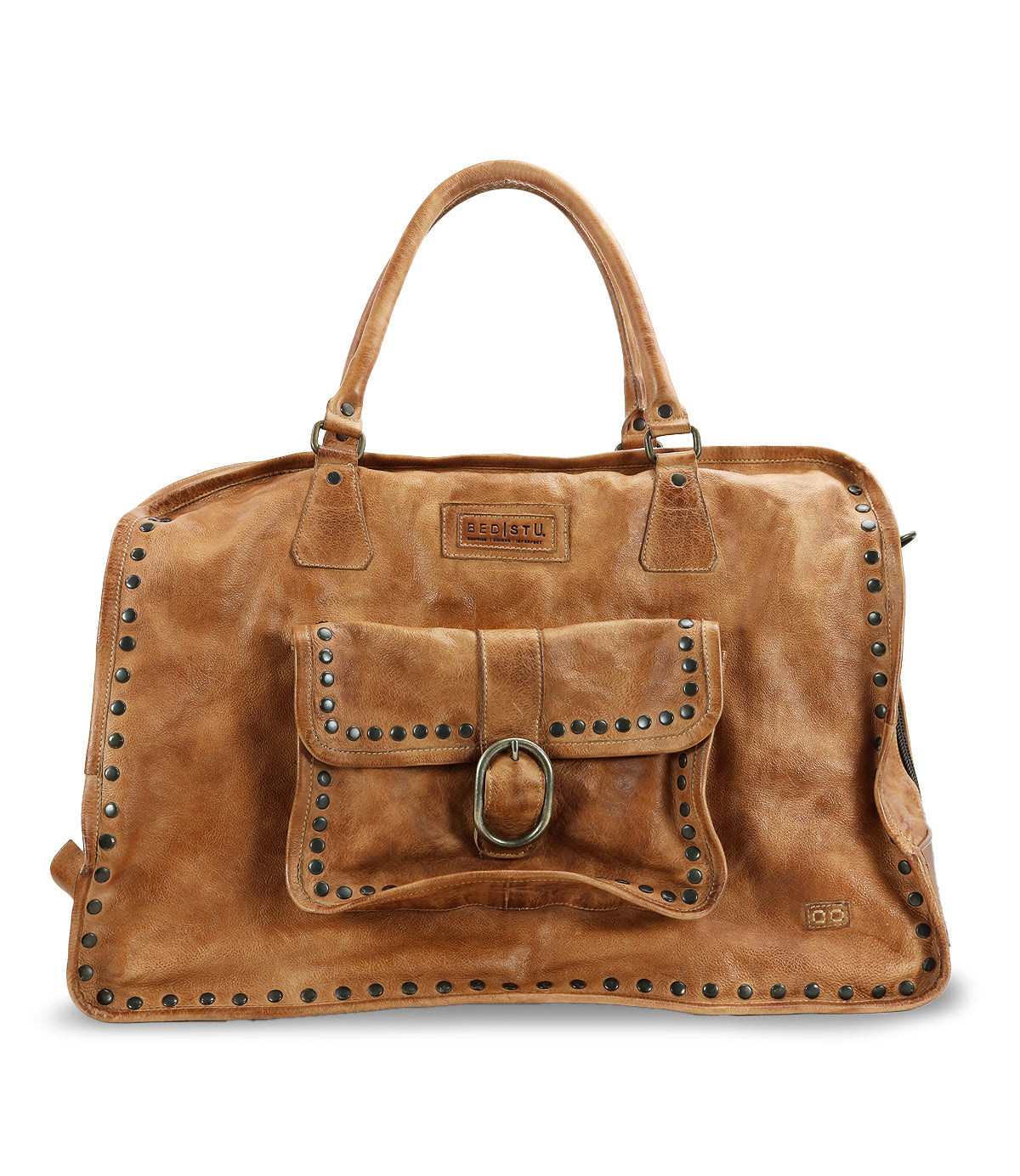 The Loaf by Bed|Stü is a brown leather handbag with double handles, a front pocket accented by a buckle, and metal stud detailing along the edges and pocket—making it a stylish travel bag for your next getaway.