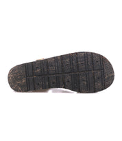 The image displays the textured black sole of the Bed|Stü Lone sandal, viewed from the bottom against a white background—highlighting the distressed design and contoured footbed crafted for comfort and support.