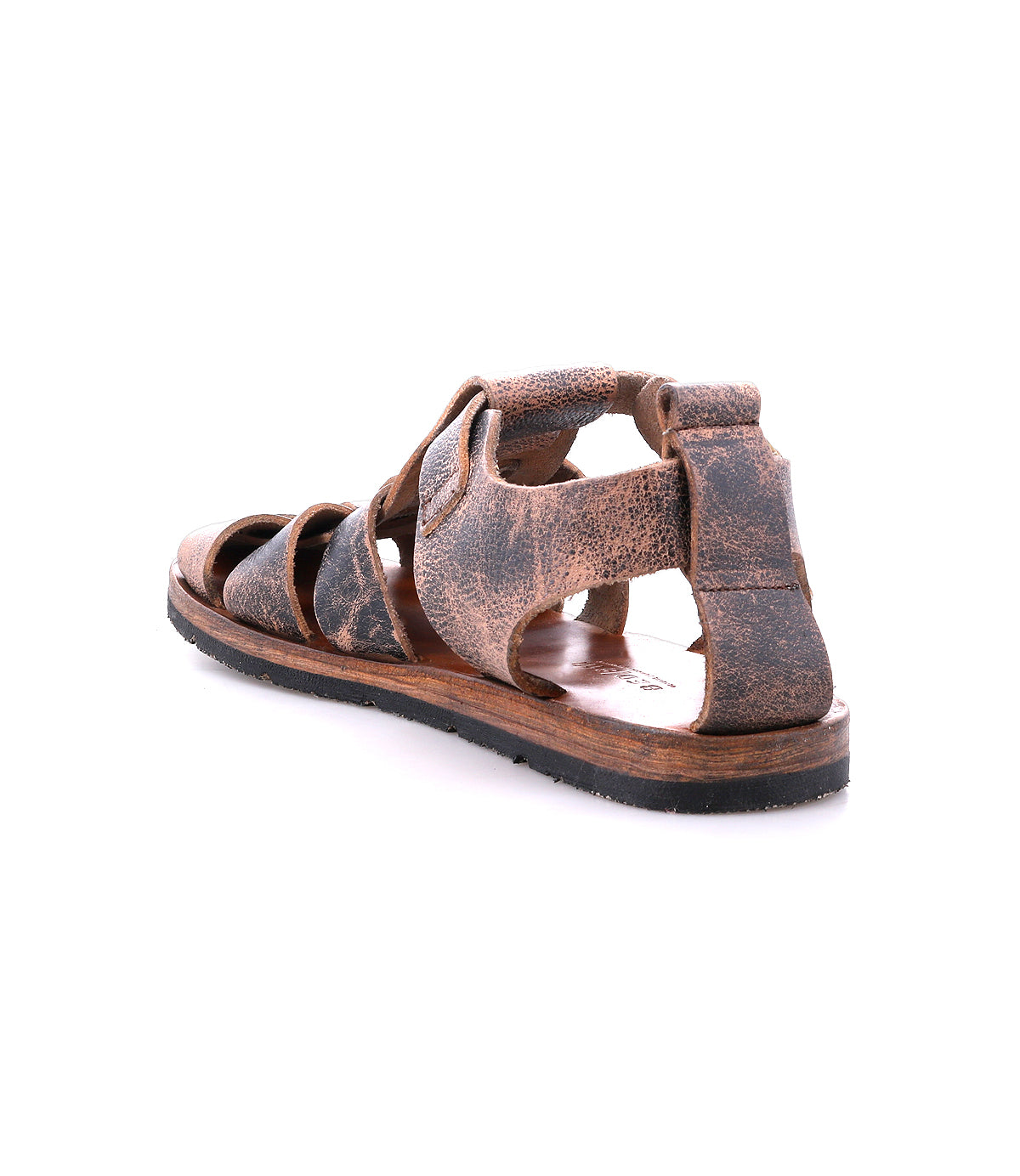 A single Lone sandal by Bed|Stü, crafted from brown distressed leather with a worn finish, features an open-toe design and thick straps with an antique brass buckle, shown angled from the back on a white background.