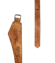 The Lucen belt by Bed|Stü is a brown leather boho-chic accessory featuring a wide section, intricate floral carvings, a metal buckle, and multiple adjustment holes—an expressive piece that adds artistic flair to any outfit.