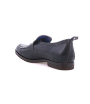 The Lumaro by Bed|Stü is a black men’s loafer made from smooth leather, featuring a low brown heel, displayed from the back angle against a white background.