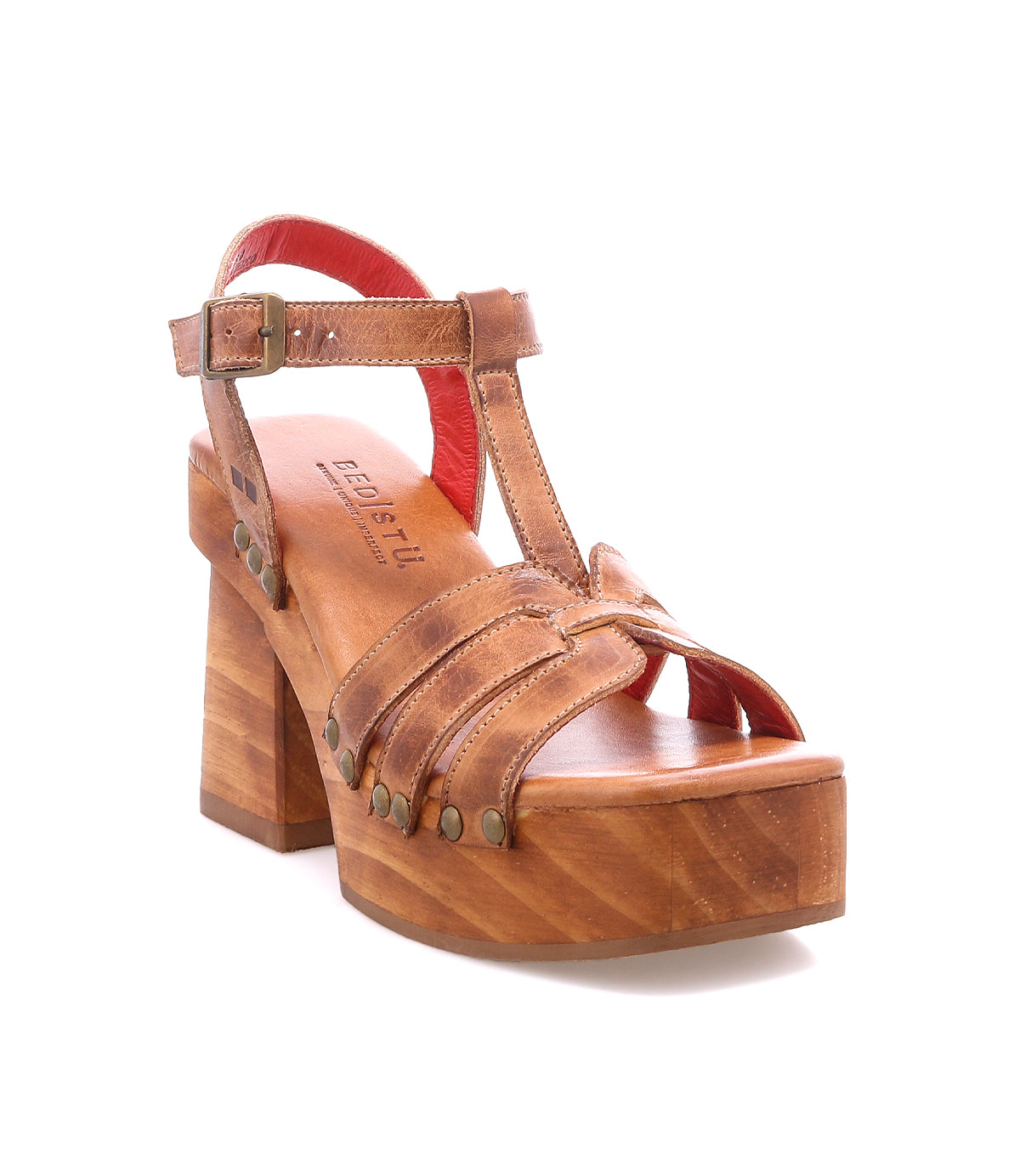 The Lyxon by Bed|Stü is a brown leather platform sandal featuring a chunky wooden heel, open-toe silhouette, T-strap design, buckle closure, and metal rivet detailing.