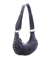 The Madre hobo bag by Bed|Stü is a statement-making black leather shoulder bag featuring metal studs along the side and an adjustable shoulder strap, showcased against a white background.