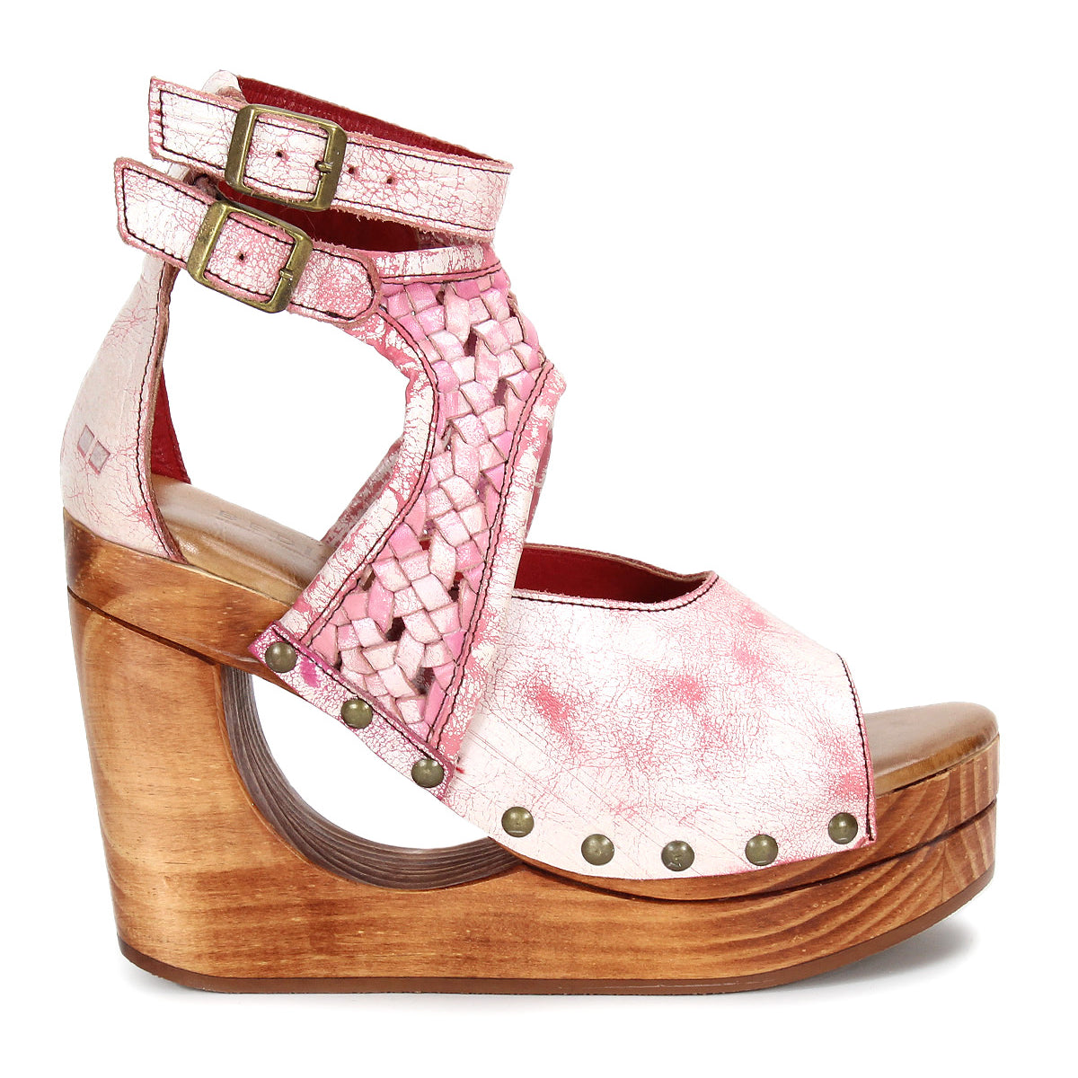 The Magic sandal by Bed|Stü features a handwoven pink and white leather upper, double ankle buckles, and a sculpted wooden platform heel accented with metal rivet details.