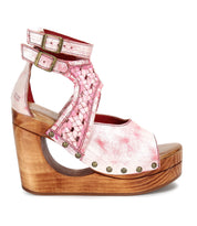 The Magic sandal by Bed|Stü features a handwoven pink and white leather upper, double ankle buckles, and a sculpted wooden platform heel accented with metal rivet details.