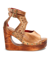 Introducing Bed|Stü’s Magic wedge sandal—a tan leather shoe featuring a handwoven upper with intricate woven details, chic peep-toe styling, adjustable ankle straps with buckles, metal stud embellishments, and a sculpted wooden platform wedge heel accentuated by bold cut-out designs.