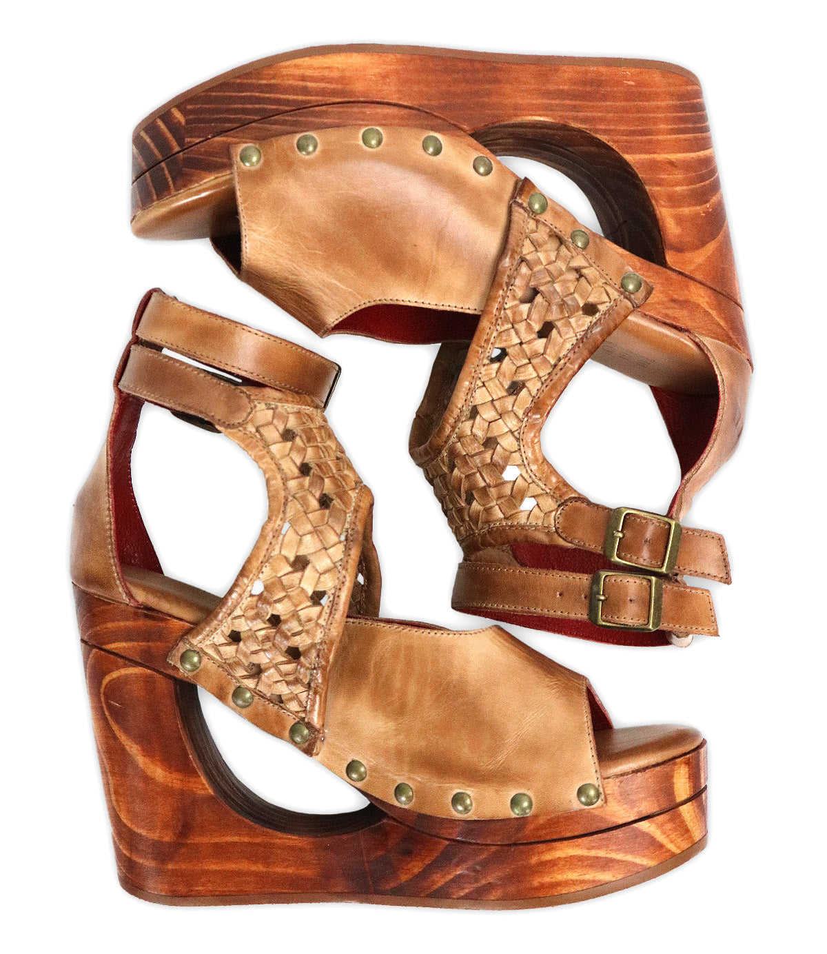 A pair of Bed|Stü Magic brown leather wedge sandals, featuring a handwoven leather upper, sculpted wooden wedge, brass stud detailing, ankle straps with buckle closures, and a refined peep-toe design, are placed side by side facing opposite directions.