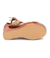 The Bed|Stü Magic platform sandal is shown from the bottom, highlighting its thick, flat sole with a textured finish and exposed rivets on the handwoven leather upper section.