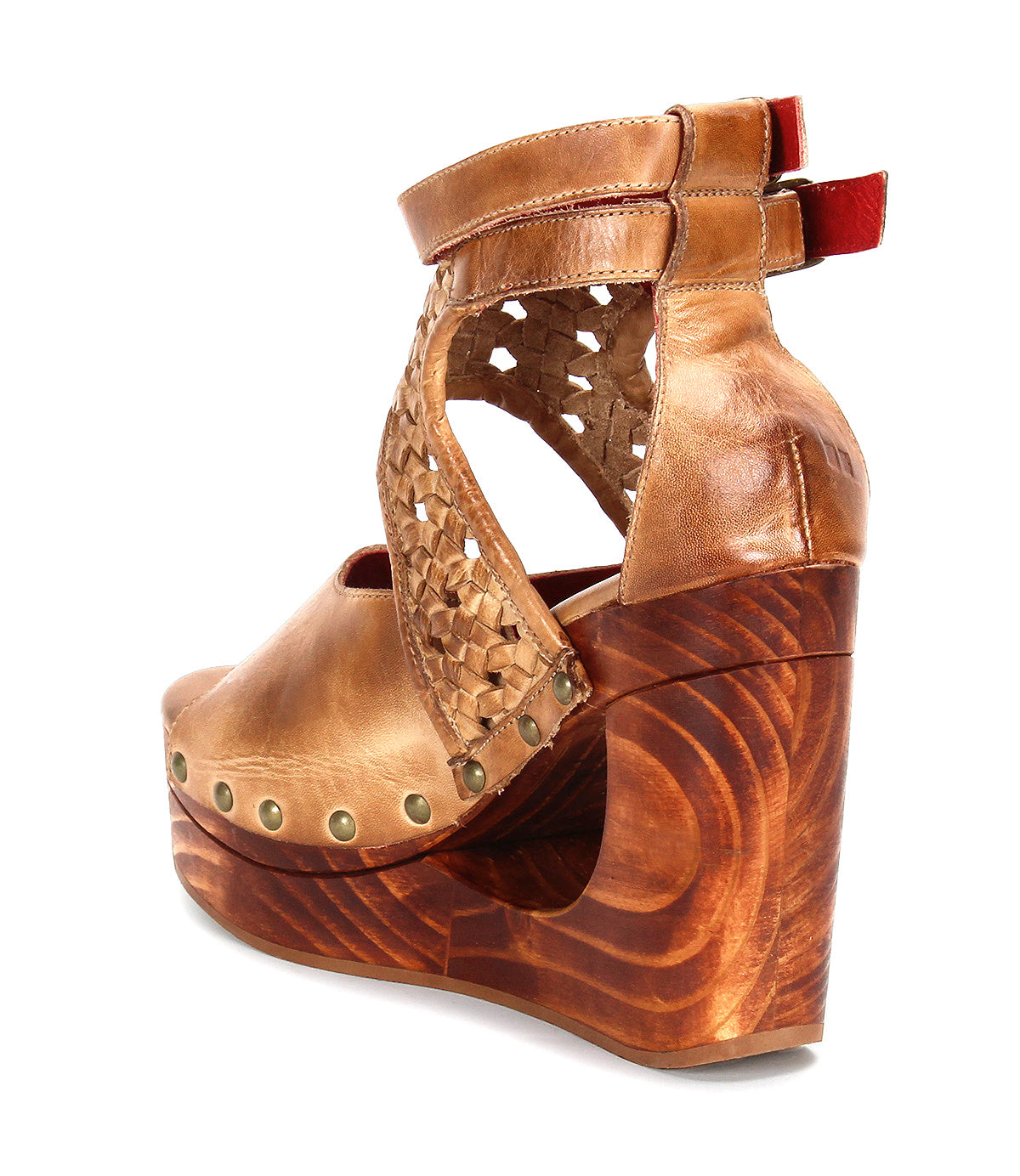 The "Magic" wedge sandal by Bed|Stü showcases a tan handwoven leather upper with woven side panels, metal stud detailing, sculpted wooden platform wedge heel, and two ankle straps highlighted with red accents at the back.