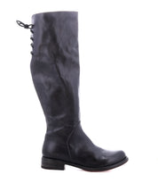 A single Manchester boot by Bed|Stü in black leather is shown in side profile against a white background, featuring a modern classic knee-high design with an elegant lace-up detail at the back upper shaft and a low, comfortable flat heel.
