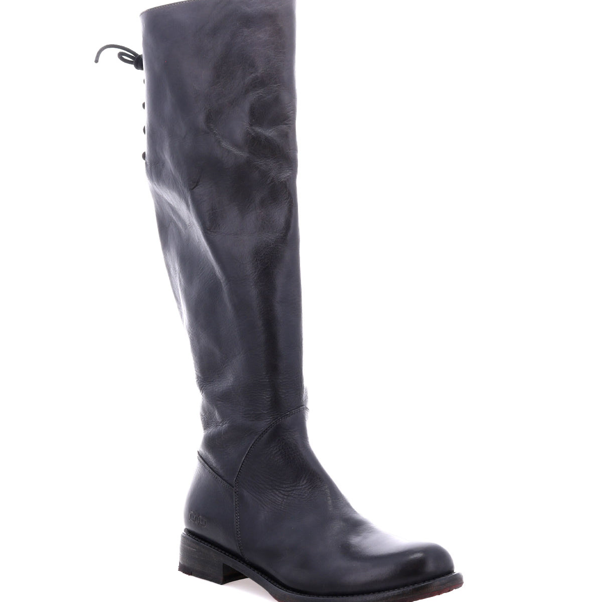 The Bed|Stü Manchester boot, crafted from sleek black leather, showcases a tall silhouette with an elegant back lacing detail and a comfortable flat heel. Presented against a white background, this modern classic effortlessly blends style and comfort for any occasion.