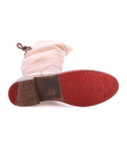 The Bed|Stü Manchester boot in light beige leather is pictured lying on its side, displaying a textured red rubber outsole and a brown block heel.