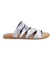 Introducing the Margin by Bed|Stü: a silver strappy slide sandal crafted with a leather upper, flat tan sole, and textured finish—shown from the side on a white background. This elegant design is a must-have addition to your summer wardrobe.