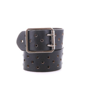 Introducing the Bed|Stü Mccoy: a black leather strap belt featuring round metal holes and a sturdy metal buckle, neatly coiled with the buckle facing forward for a personalized fit.