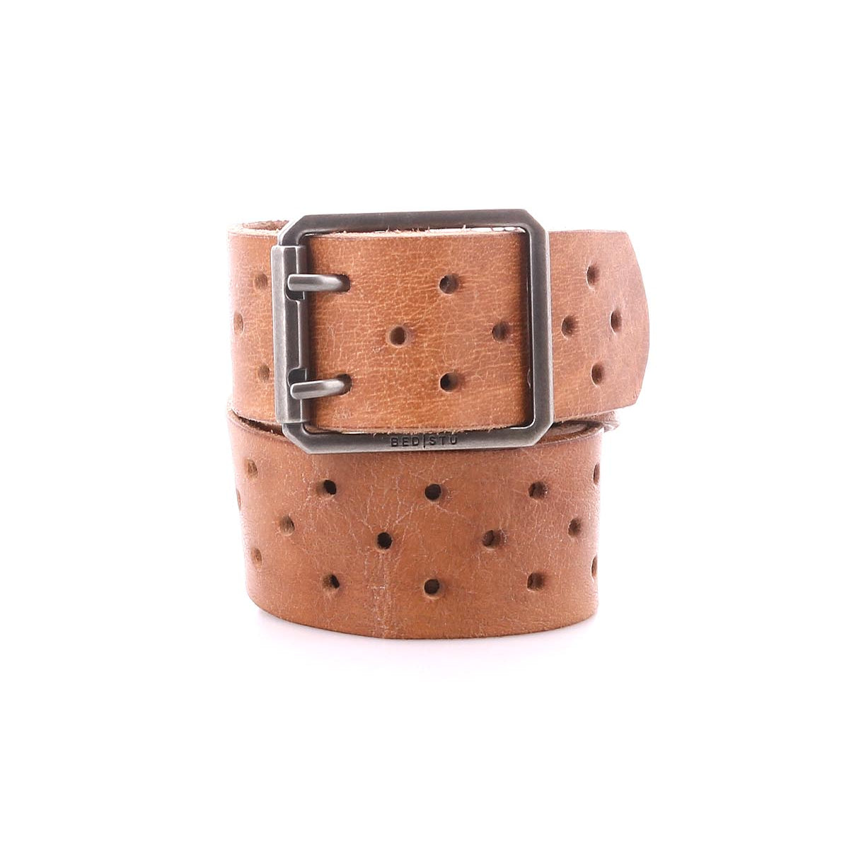 The Bed|Stü Mccoy is a brown leather strap belt featuring multiple round holes and a durable metal buckle, shown coiled on a white background for adjustable, customizable fit.