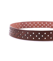 The Bed|Stü Mccoy is a brown leather belt featuring a durable metal buckle and multiple evenly spaced round holes along the strap, displayed in a circular shape on a white background for an adjustable, customizable fit.