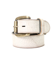 The Bed|Stü Meander belt, crafted from distressed white leather with a visible textured finish and featuring an antique metal buckle, is displayed rolled up against a plain white background.