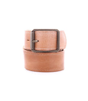The Bed|Stü Meander belt, crafted from tan distressed leather and featuring an antique metal buckle, is rolled up and displayed on a white background.
