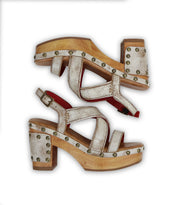 The Bed|Stü Mediation women's heeled slingback sandals feature wooden soles, white textured leather straps adorned with metal studs, cushioned insoles, and red interior accents. The sandals are displayed side by side on a white background.